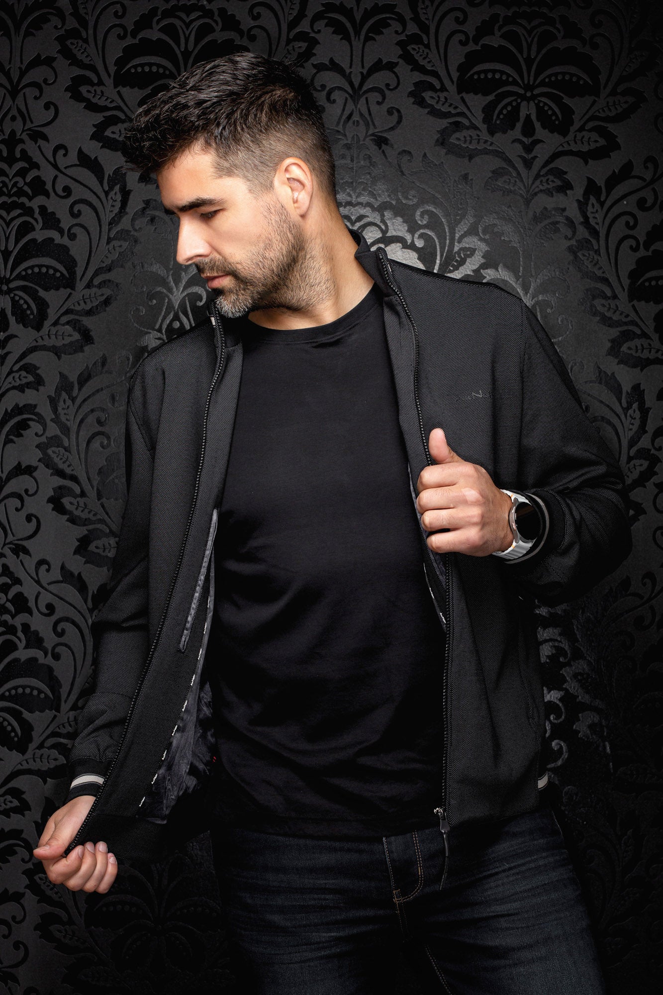 Au Noir men's angled open view of black textured bomber jacket showing dark lining and front zipper, side view