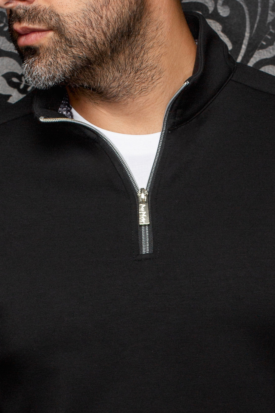 Au Noir men's black quarter-zip sports jacket with stand collar, silver zipper, and patterned inner trim, close-up
