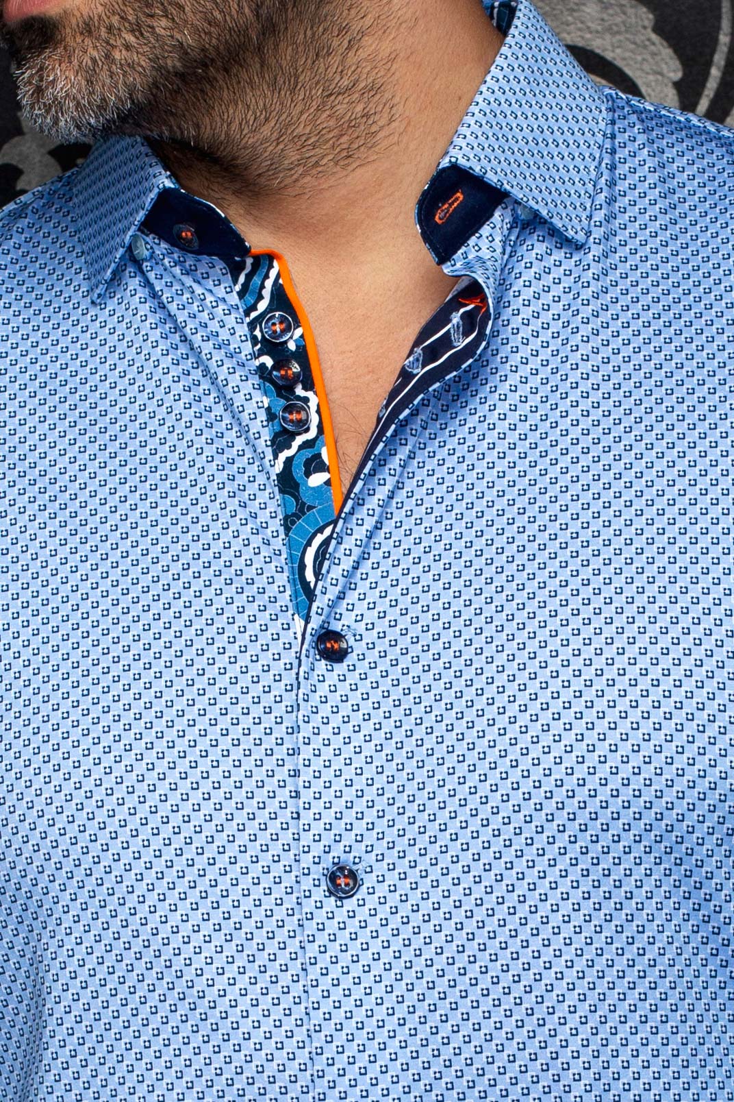 Col de chemise bleue pâle à motif, boutons, patte marine et passepoil orange pour homme par Au Noir, en gros plan
