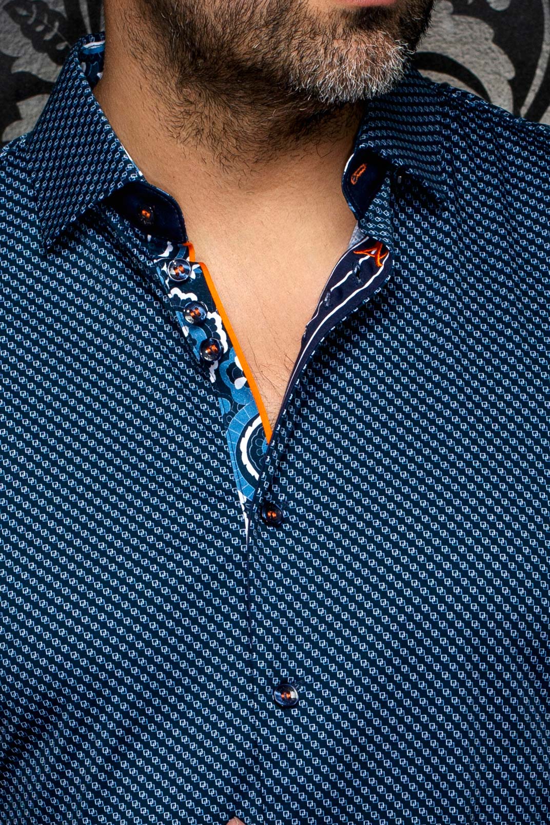 Gros plan du col de chemise bleu marine à micro motif avec patte contrastante orange pour homme par Au Noir