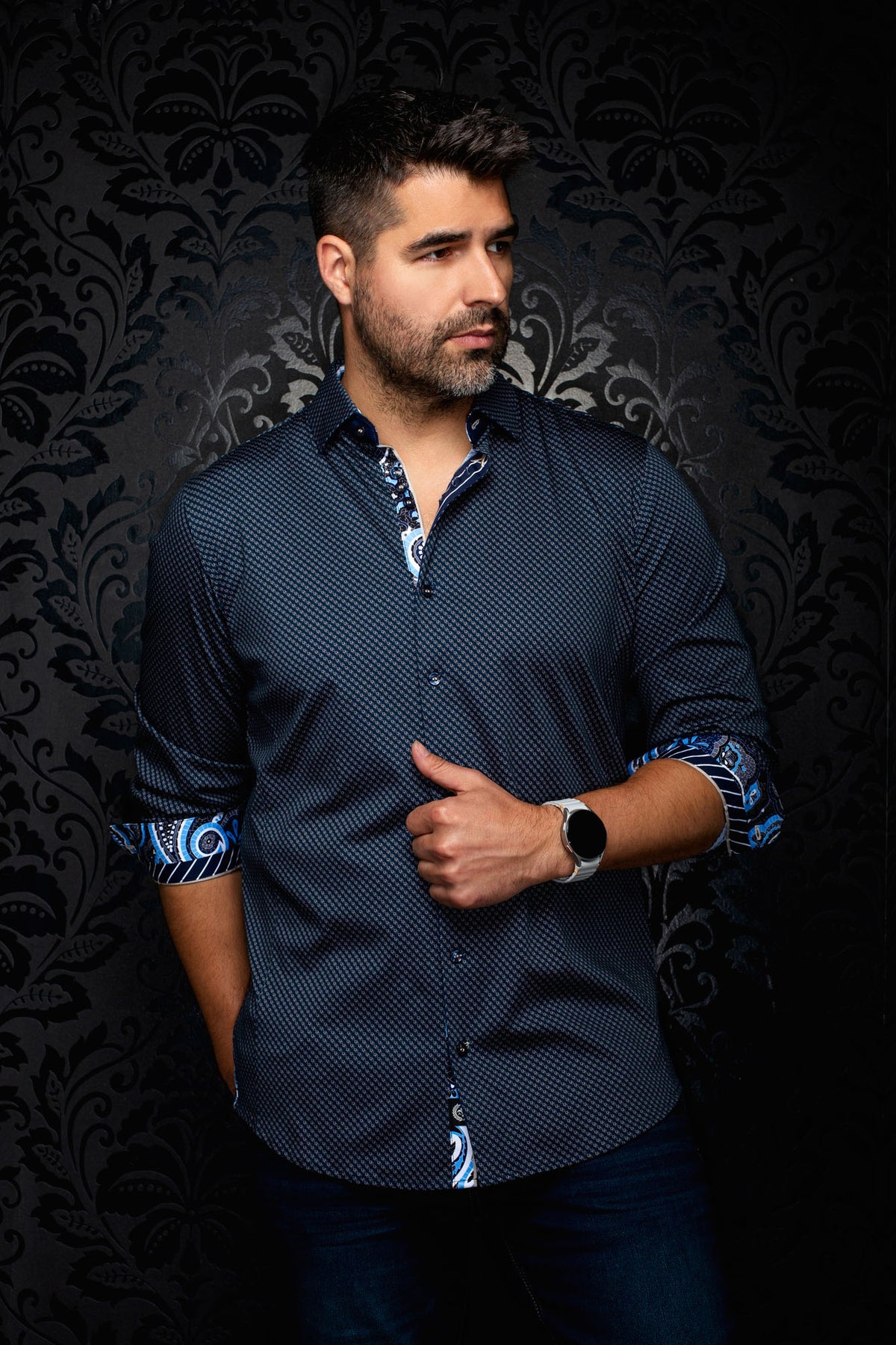 Men's navy patterned button-front shirt on model with rolled cuffs showing blue floral contrast trim by Au Noir