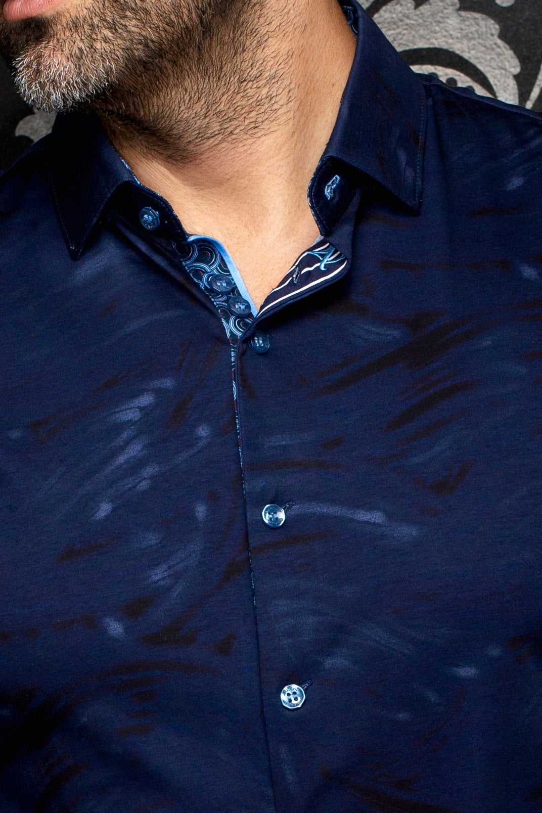 Au Noir men's navy button-up shirt collar, blue buttons, and contrast patterned inner placket, close-up