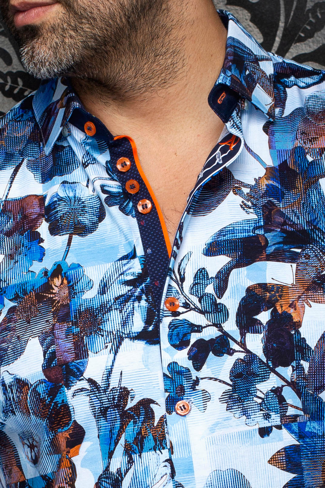 Gros plan du col de la chemise bleue pâle fleurie, patte marine, boutons et bordure orange pour homme par Au Noir