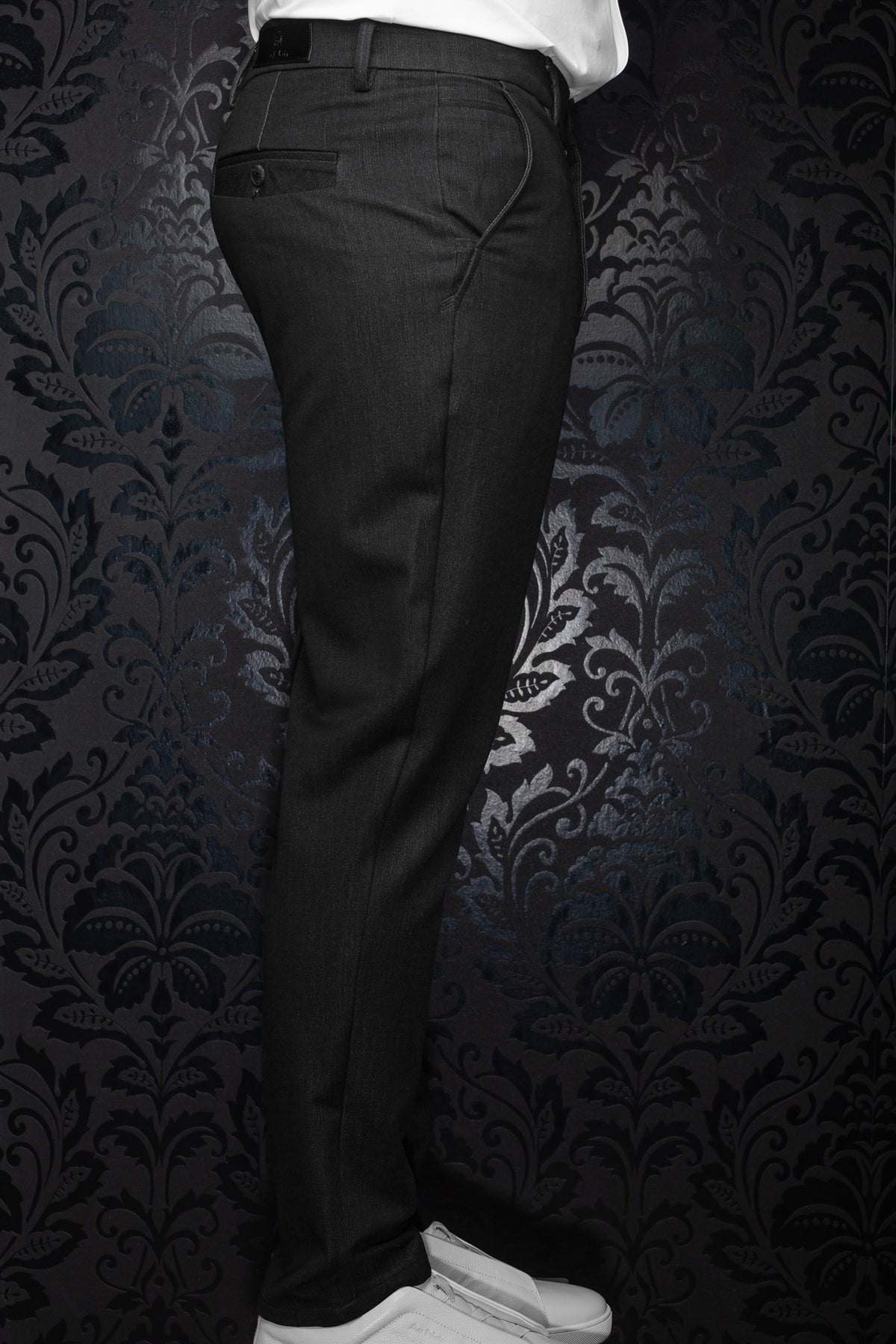 Au Noir men's black pants with belt loops, rear welt pocket, and curved side pocket stitching shown from the side