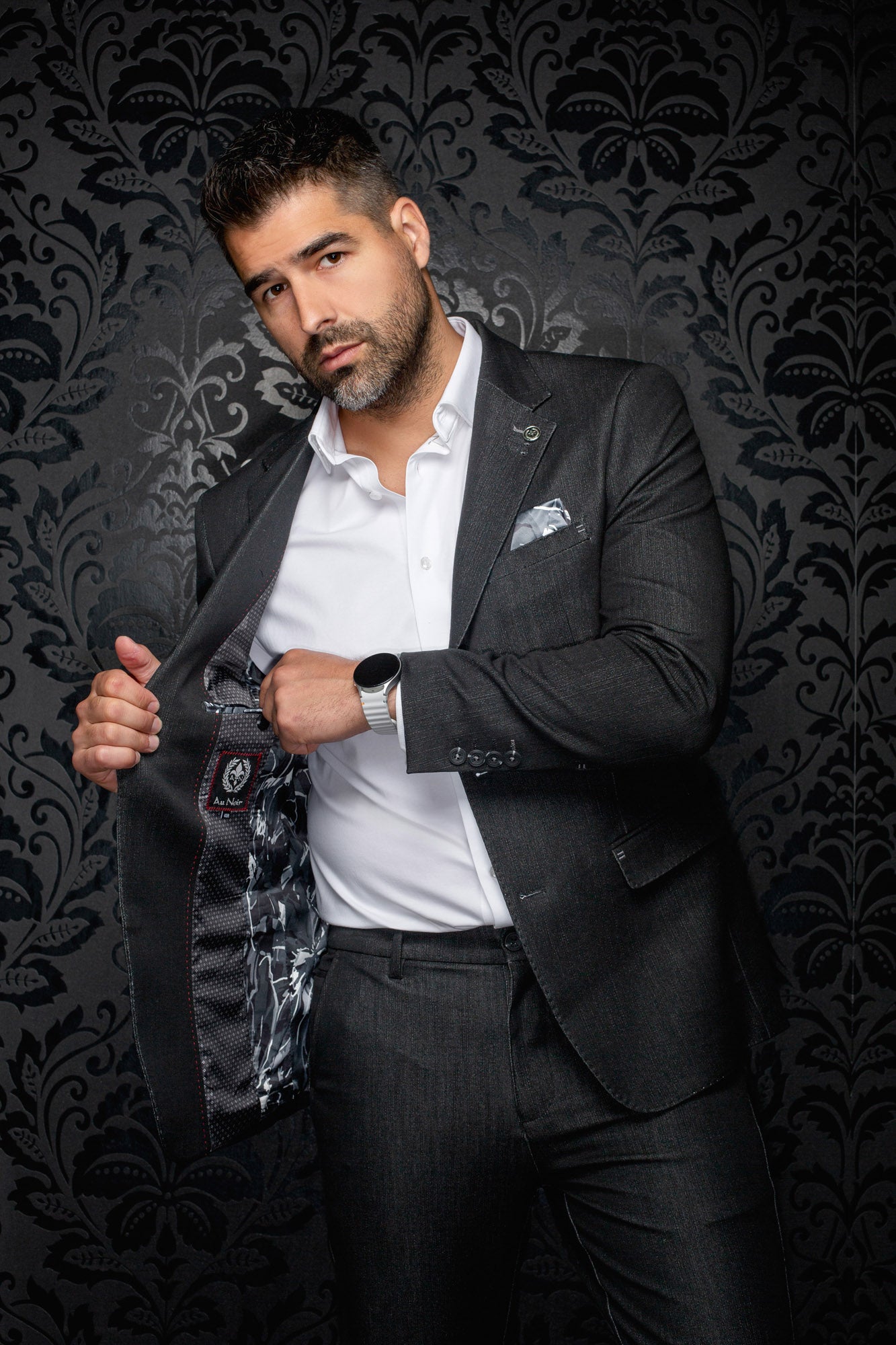 Men's open dark charcoal blazer showing patterned lining, red stitching, and interior label detail by Au Noir