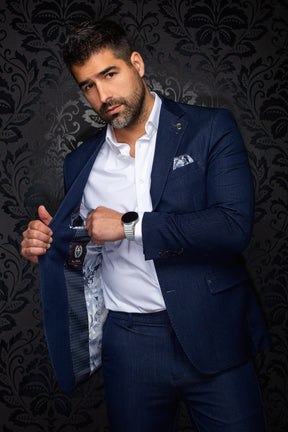Au Noir men's navy blazer held open showing patterned lining, interior label, and lapel pin on a model, detail view
