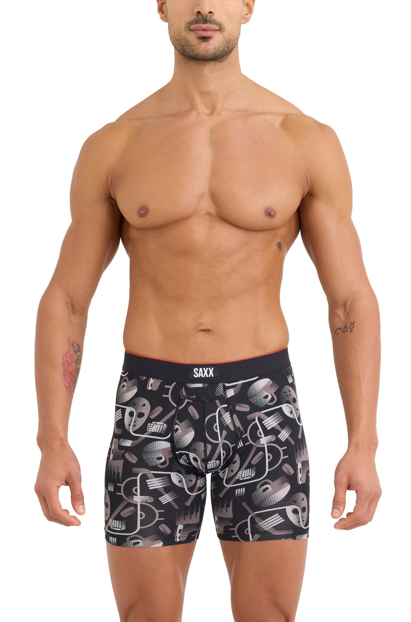 Front model view of men's black hockey-print boxer underwear with SAXX logo waistband and pouch