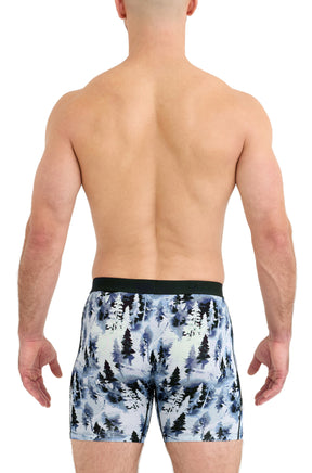 Saxx men's model back view of blue forest-print boxer underwear with straight leg hems and black waistband