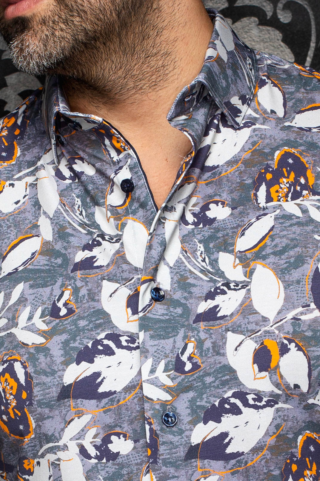Col de la chemise grise à imprimé floral blanc et orange avec boutons foncés pour homme par Au Noir, en gros plan