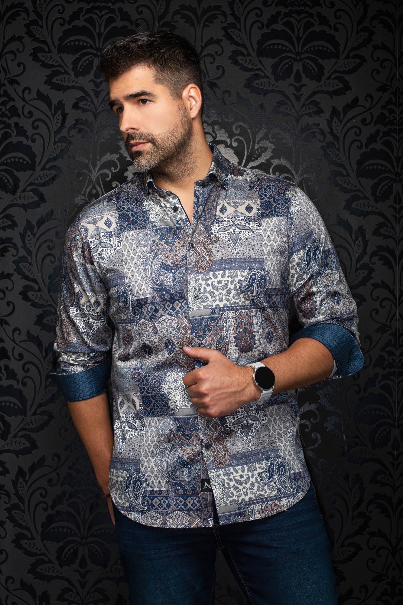 Au Noir men's front angled view of navy paisley patchwork button-up shirt with rolled contrast blue cuffs, side view