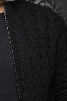 Au Noir men's black cable-knit merino jacket shoulder and front zipper edge showing raised texture, close-up