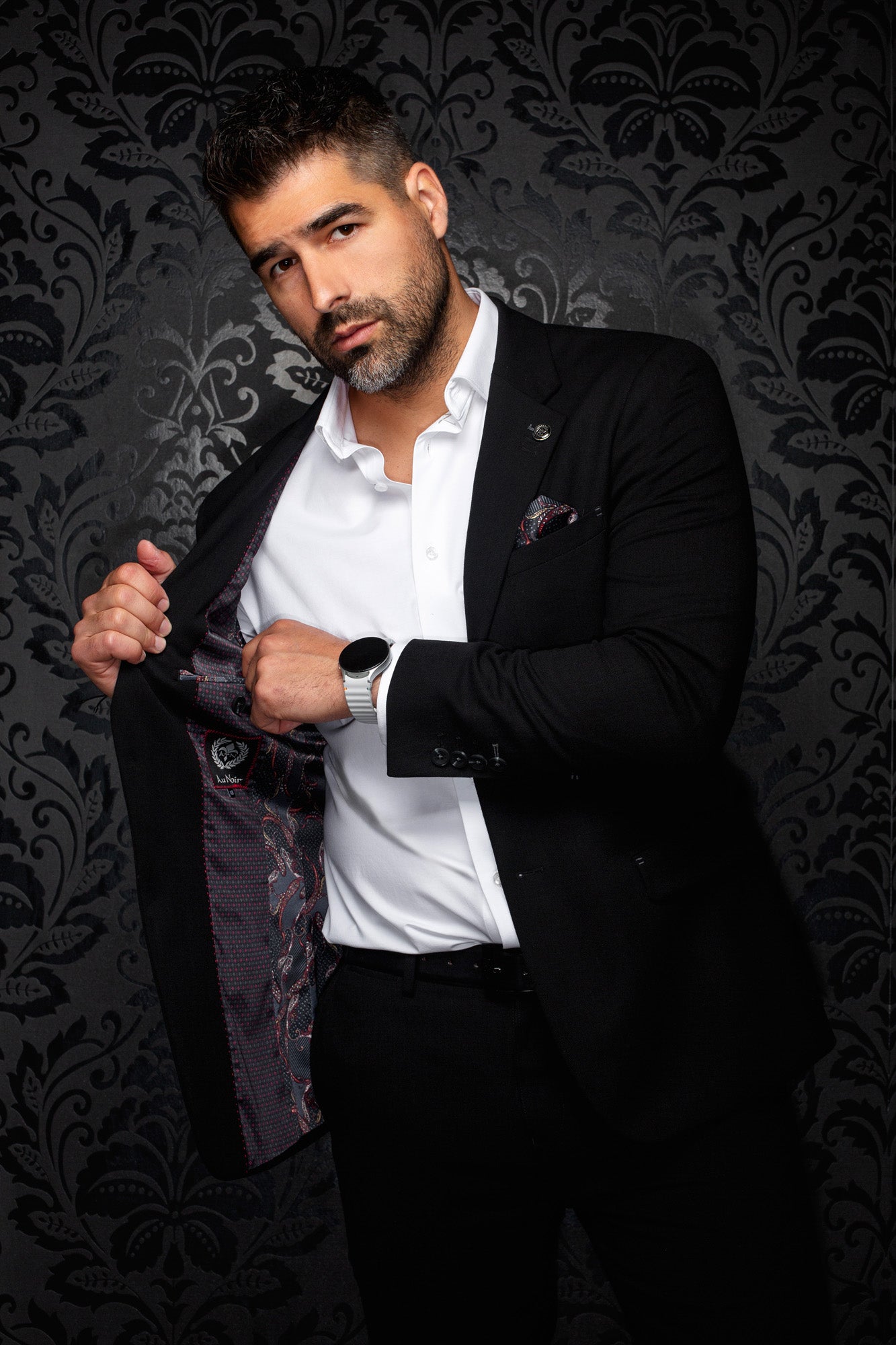 Men's angled view of a black blazer opened to show dark paisley lining with burgundy accents, detail view by Au Noir