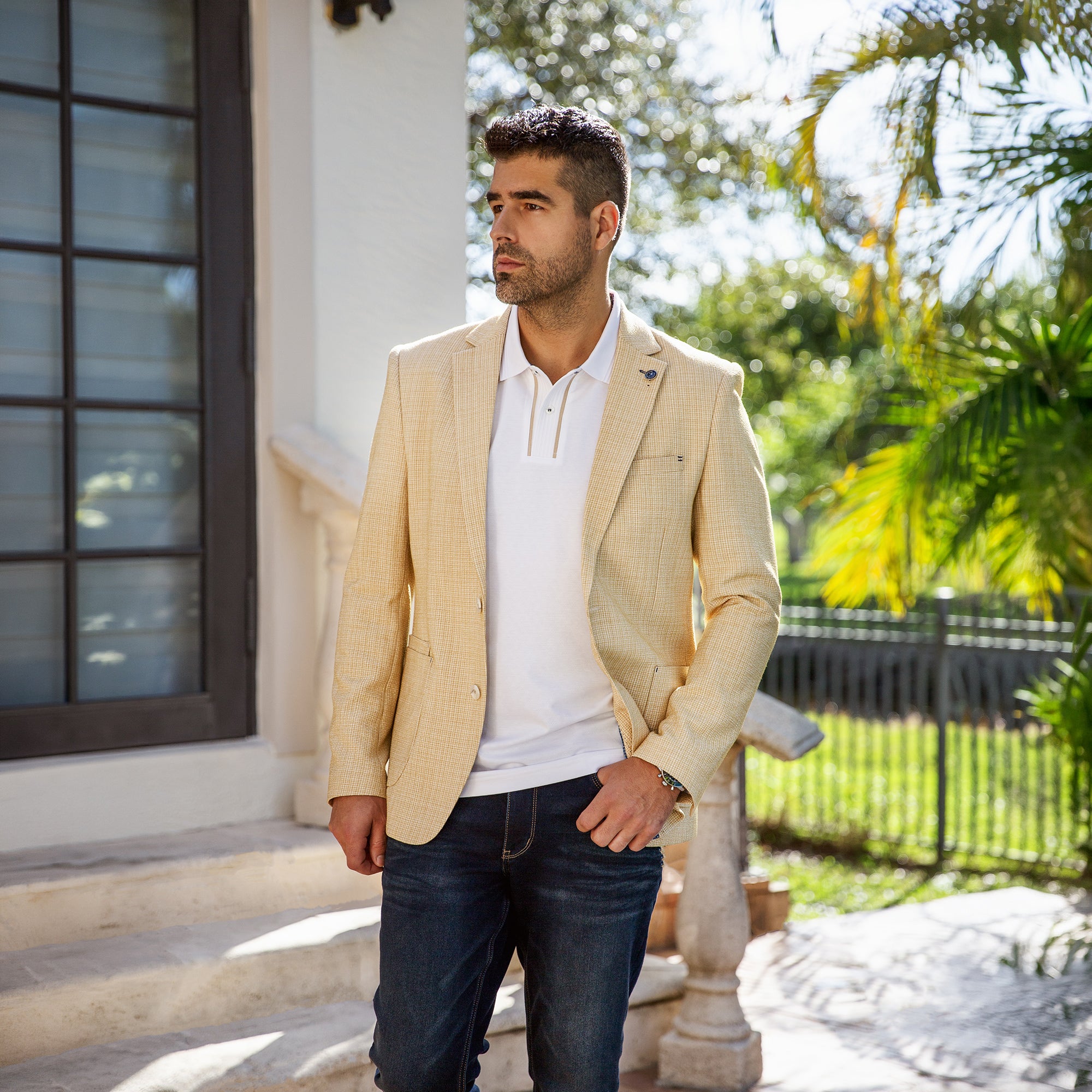 Au Noir men’s beige Blazer with white polo and dark jeans, styled in a sunny chic outdoor setting.
